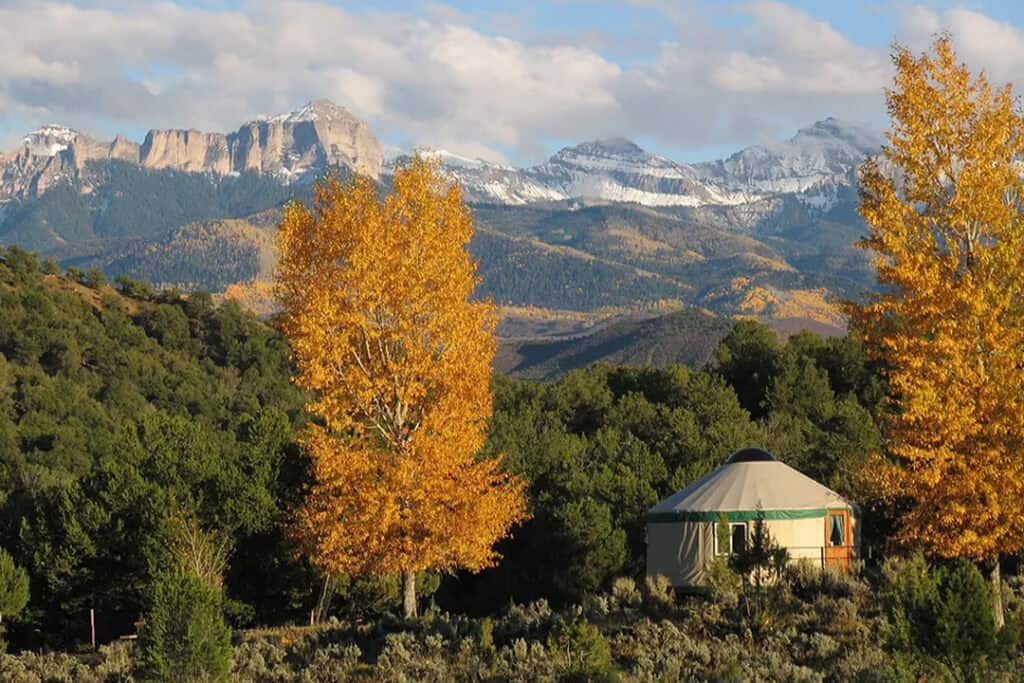 Golden leaves on trees and a yurt in the scenic Colorado Rockies. 